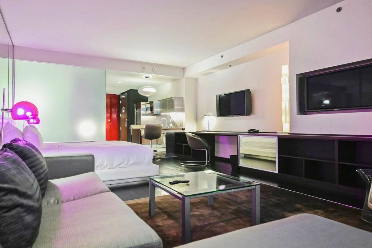 A modern living room with a sofa, a coffee table, and a TV.