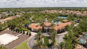 A residential area with a central building featuring a swimming pool, surrounded by houses and greenery. - Solterra 6BR | Private Pool & 4 Ensuites (davenport)