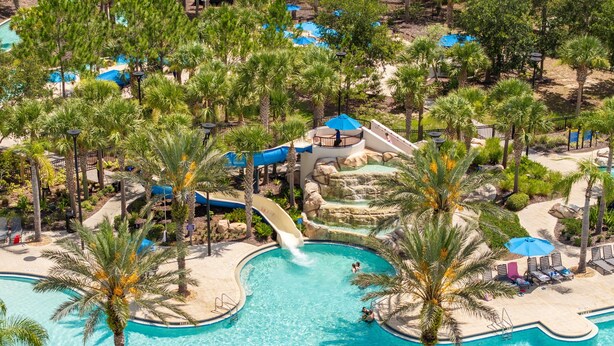 A large outdoor swimming pool surrounded by palm trees and a water slide. - Solterra 6BR | Private Pool & 4 Ensuites (davenport)