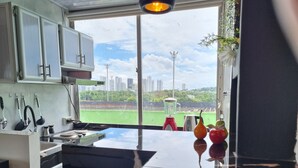 Una cocina moderna con un amplio ventanal, una licuadora y un frutero.