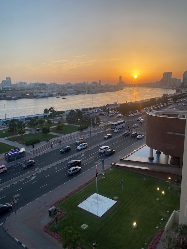 A cityscape with a river, buildings, and a sunset.