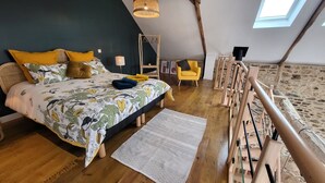 Un dormitorio con cama, una silla, una lámpara y una estructura de madera.