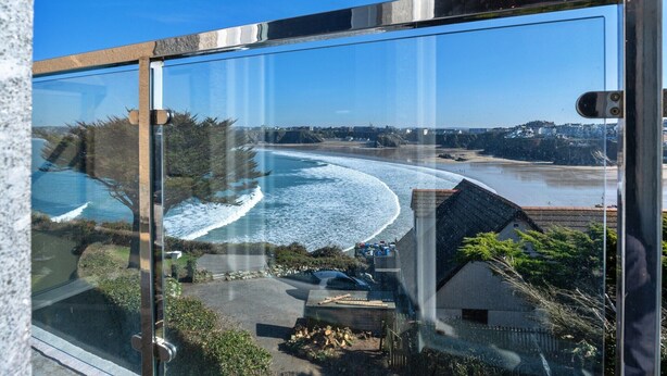 A coastal view from a high-rise building with a clear sky, a beach, and a small house in the foreground. - Apartment in Cornwall with Towan Beach Views (Newquay)