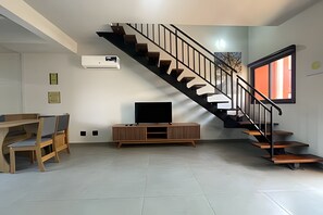 A modern living room with a staircase, a flat-screen TV, and a built-in air conditioner. -  RIVIERA PREMIUM (Santa Clara d'Oeste)