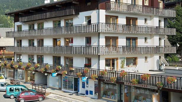 A multi-story hotel with balconies, a restaurant, and a parking area. - Central Studio for 2 in Les Gets - Balcony, Free WiFi, Linens Included (Les Gets)