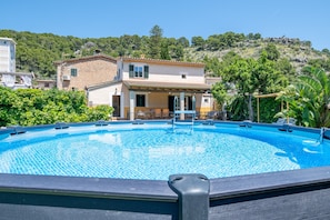 Piscina com vista para uma encosta e um edifício com telhado telhado.