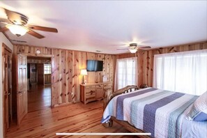 Cozy retreat with a large bed, wooden headboard, and flat-screen TV.
