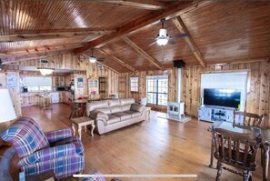 Cozy cabin-style living area with a comfortable sofa, armchair, and wood-burning stove.