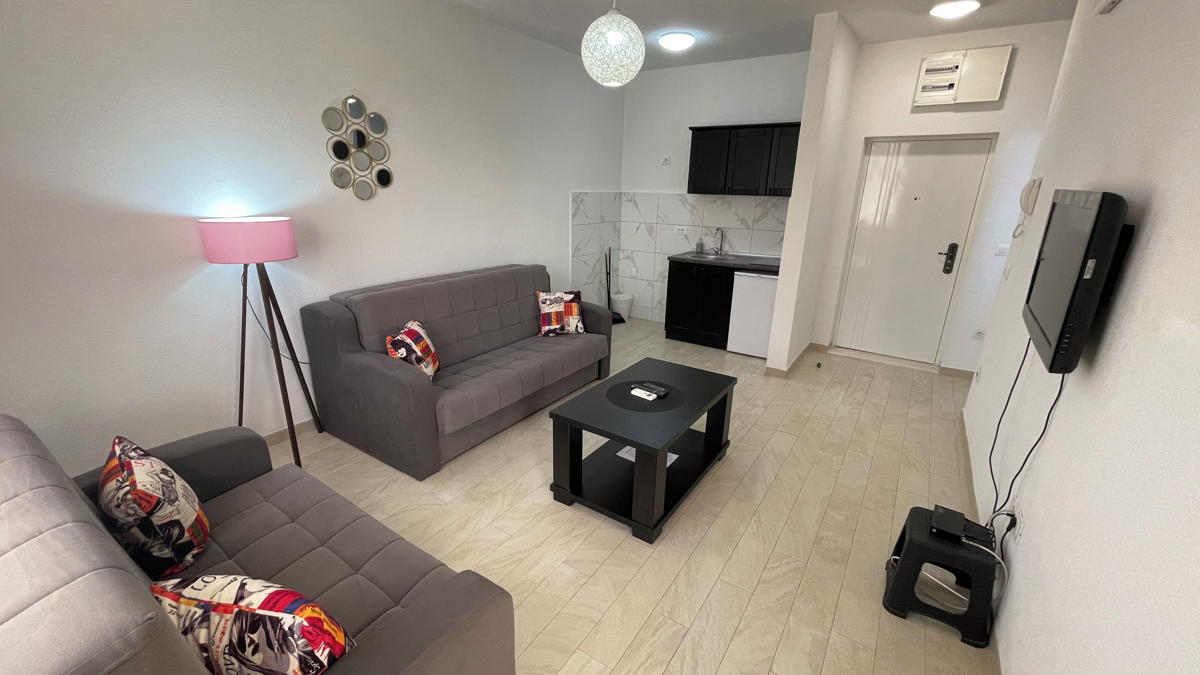 A modern living room with a grey sofa, a coffee table, and a floor lamp.