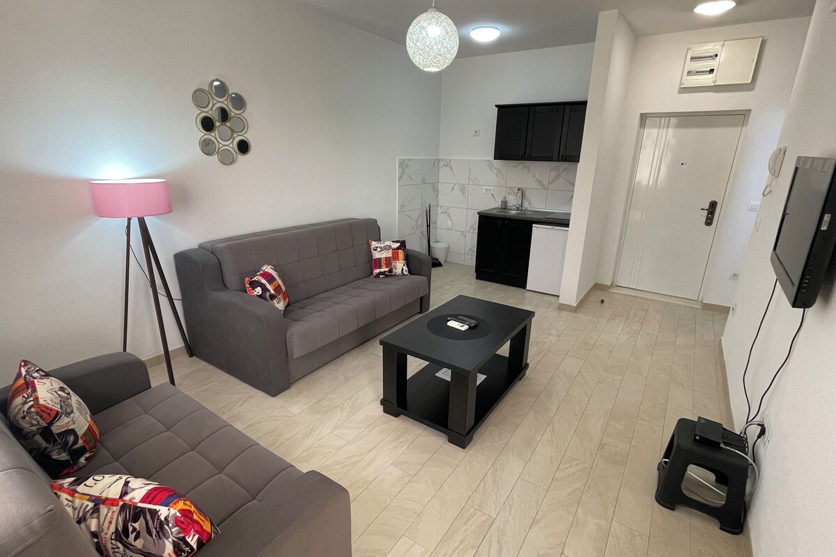 Una sala moderna con un sofá gris, una mesa de centro y una lámpara de pie.