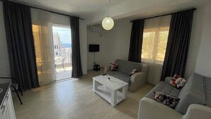 A modern living room with a sofa, a coffee table, and a TV mounted on the wall.