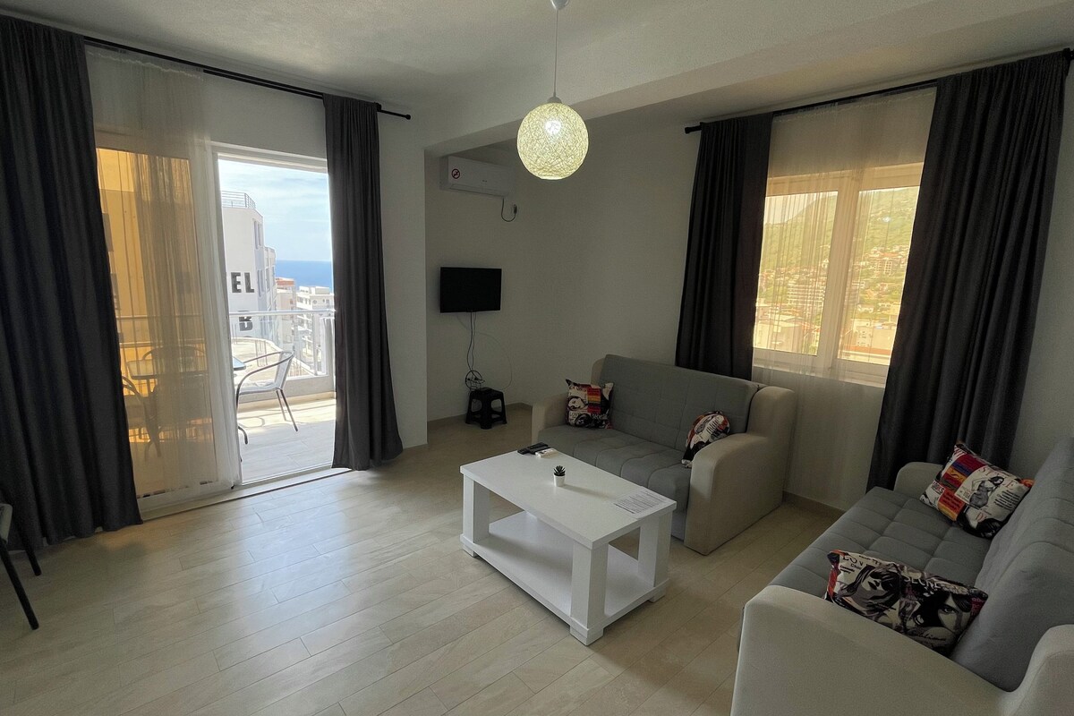 Una sala de estar moderna con un sofá, una mesa de centro y un televisor montado en la pared.