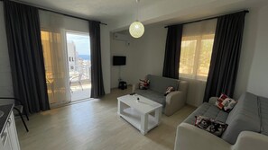 Una sala de estar moderna con un sofá, una mesa de centro y un televisor montado en la pared.