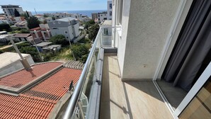 Varanda com vista para o mar e edifícios vizinhos.