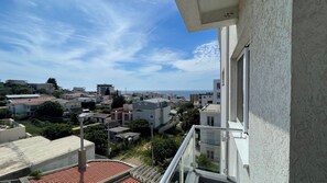 Un área residencial con edificios, cielo despejado y vista al mar.