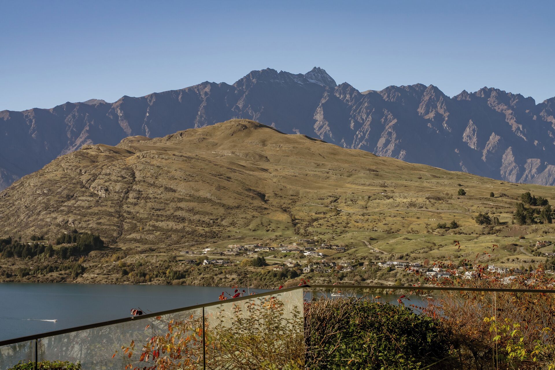 A mountainous landscape with a lake and a small settlement.