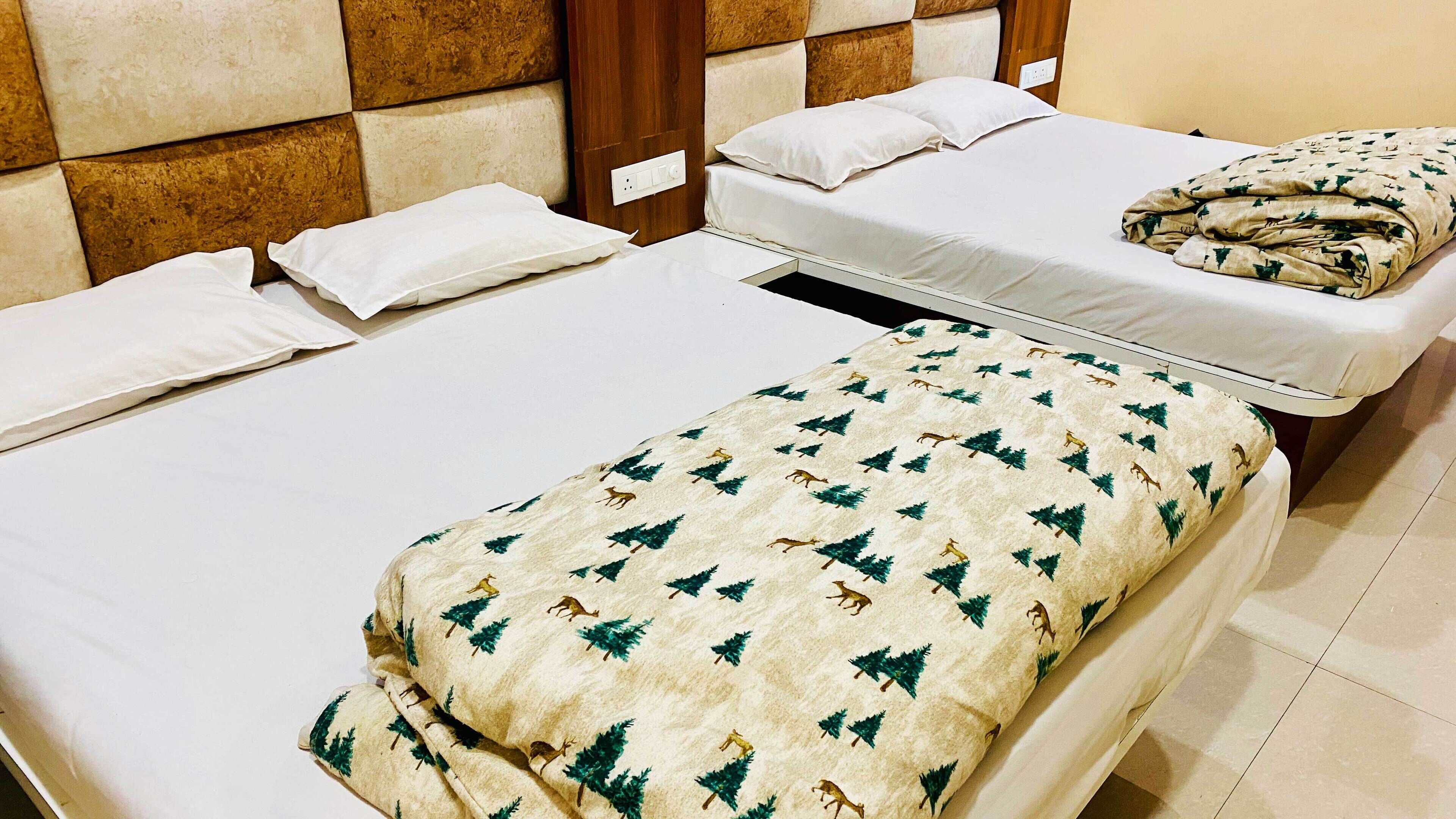 Habitación de hotel con dos camas, cabecero de madera y suelo de baldosas.