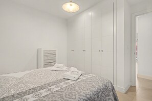A bedroom with a bed, a wardrobe, and a door.