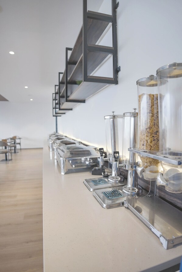 A buffet setup with clear glass containers and metal serving trays.