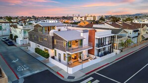 A modern residential building with a balcony, a garage, and a street view. - 200 East Balboa Oceanview Rooftop Steps to Sand, Pier, Boardwalk & Dining (Newport Beach)
