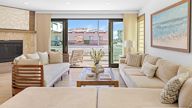 A spacious living room with a sofa, a coffee table, and a TV. - 200 East Balboa Oceanview Rooftop Steps to Sand, Pier, Boardwalk & Dining (Newport Beach)