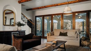 A spacious living area with a sofa, a coffee table, and a fireplace.