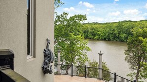 A balcony with a view of a river and forest.