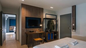 A hotel room with a bed, a desk, a TV, a wardrobe, and a bathroom. - L Nimman Boutique Hotel (Chiang Mai)