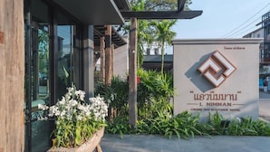 A sign for Chiang Mai Boutique Hotel, featuring a modern design with a logo and Thai script. - L Nimman Boutique Hotel (Chiang Mai)