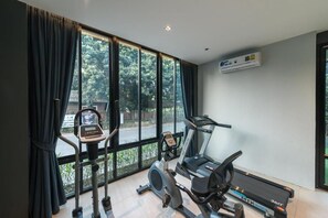 Un gimnasio en casa con cinta de correr, bicicleta estática y máquina elíptica.