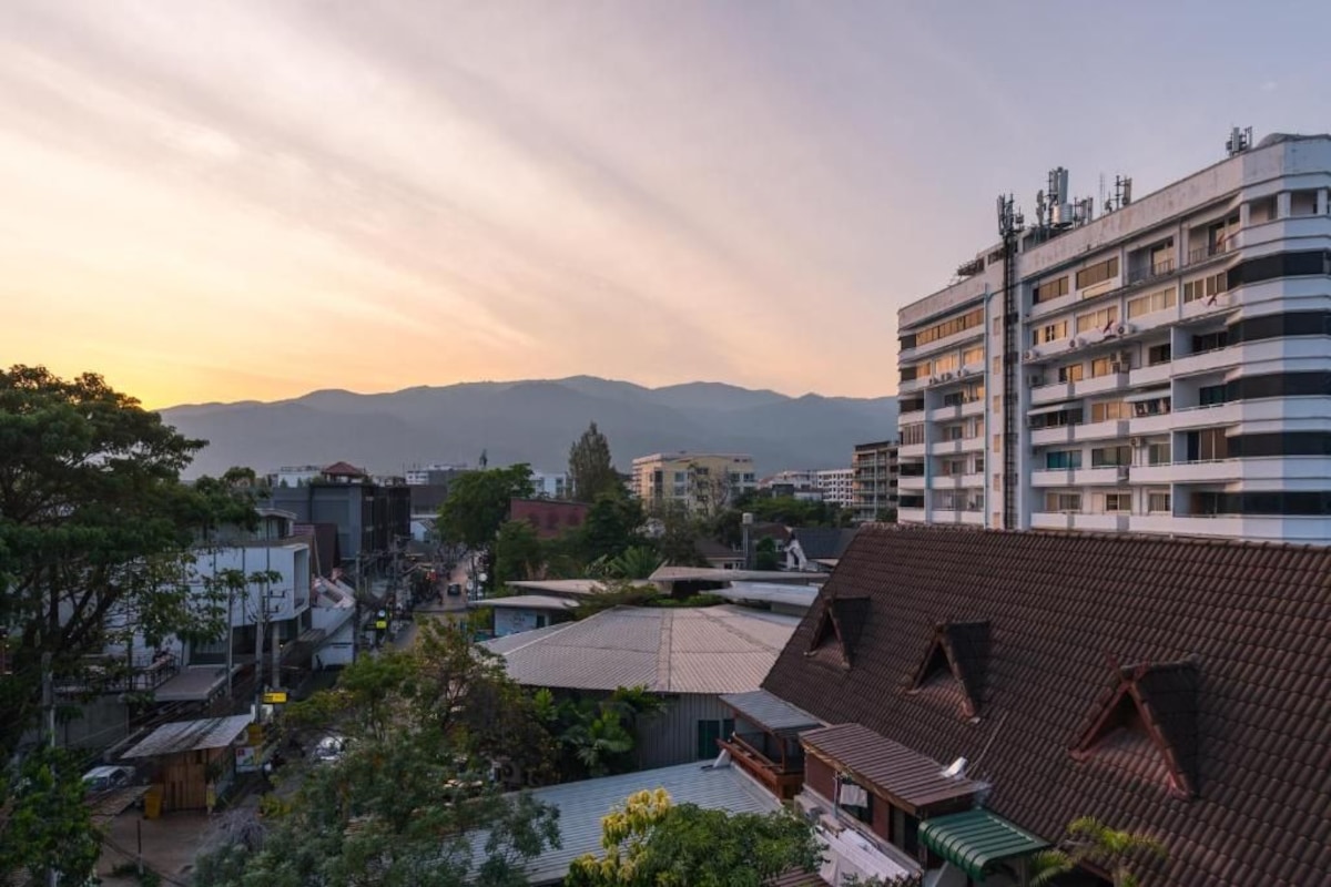 Un edificio de varios pisos con techo plano y un balcón en el segundo nivel.