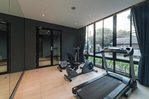 Un gimnasio moderno con cinta de correr, bicicleta estática y máquina elíptica.