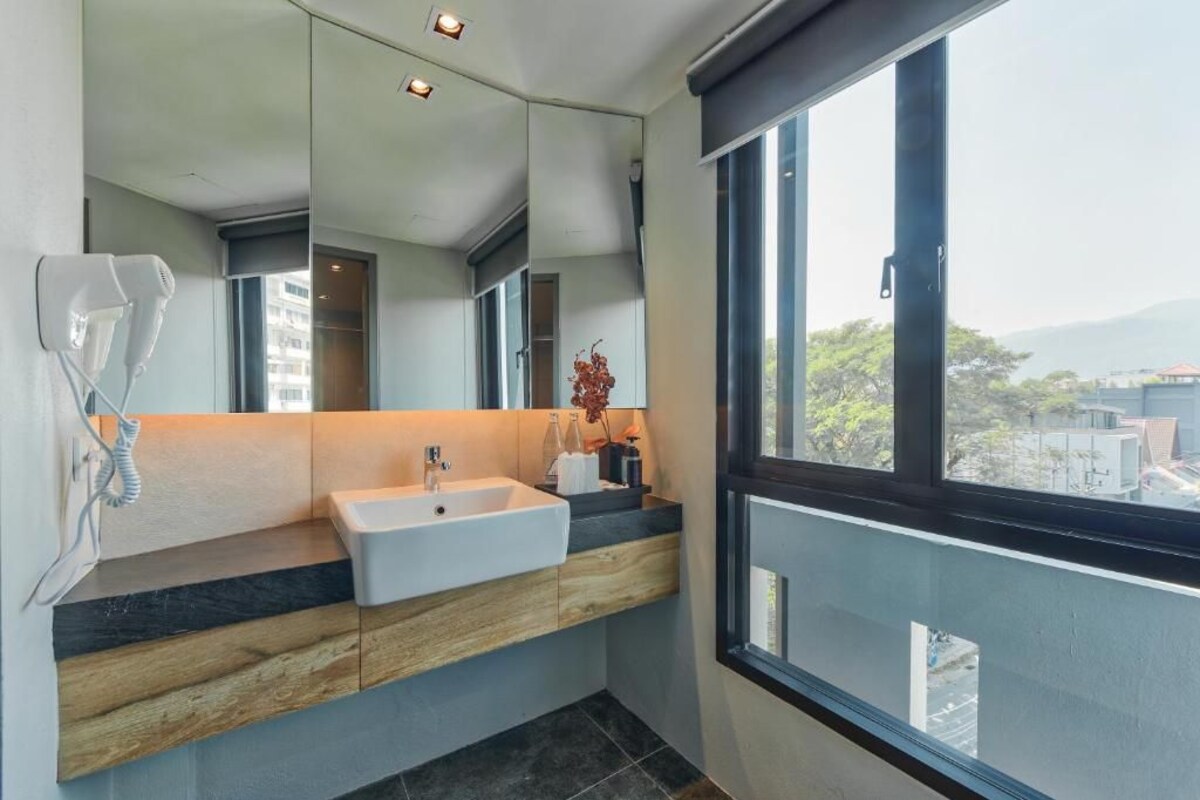A modern bathroom with a large mirror, a sink, and a telephone.