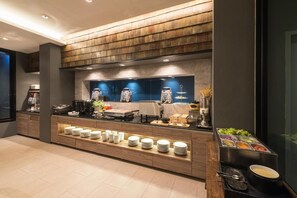 A modern kitchen with a wood panel backsplash, a buffet counter with plates and bowls, and a coffee machine. - L Nimman Boutique Hotel (Chiang Mai)