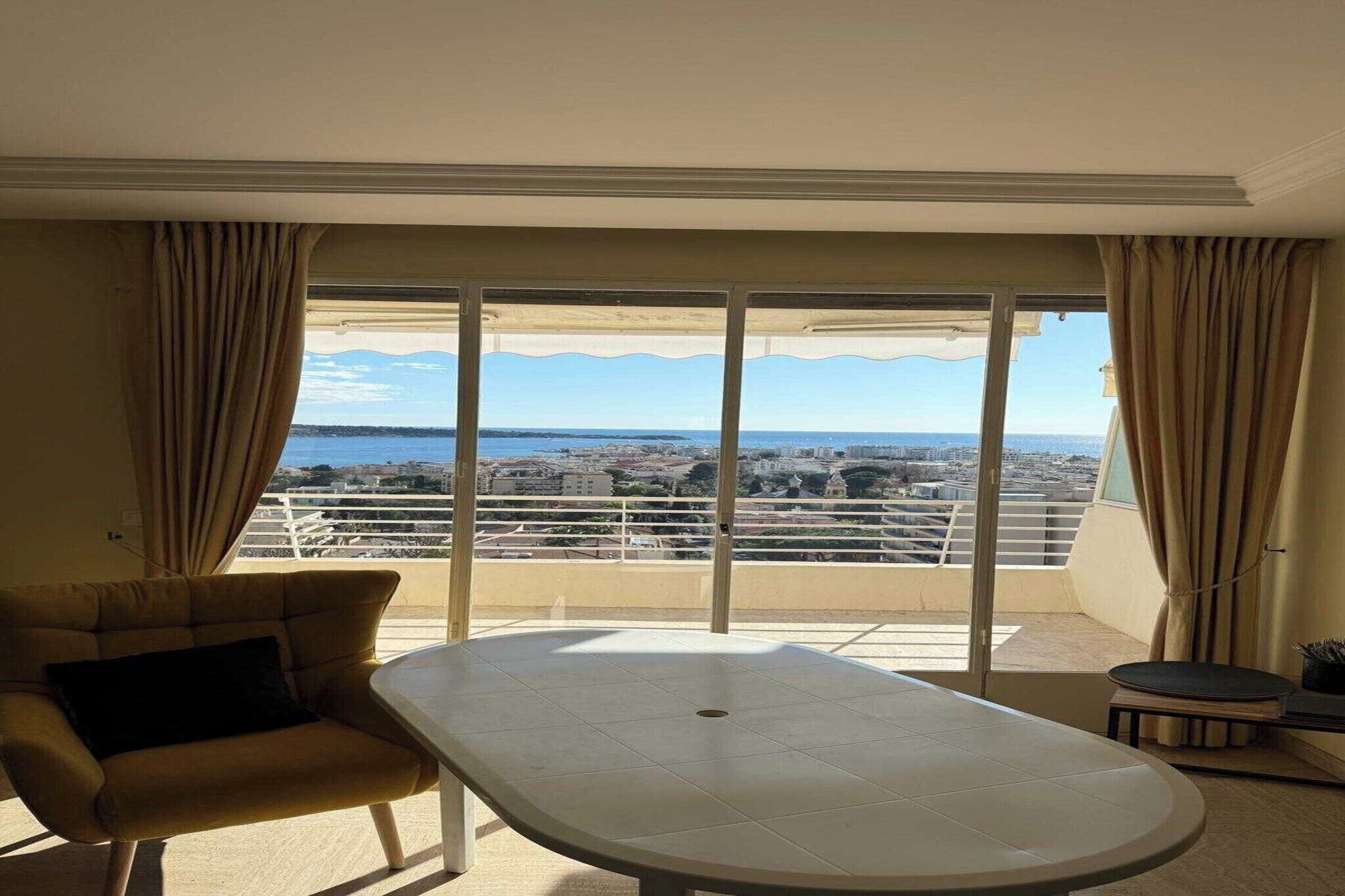 Una habitación con un ventanal grande, un sofá y una mesa.