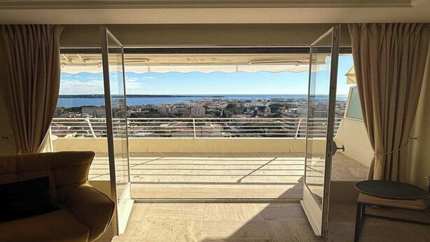 Un balcon avec vue sur la ville, un canapé et une petite table.