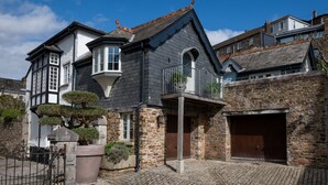 A traditional stone house with a large garage, a conservatory, and a well-maintained garden.