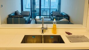 A modern kitchen with a sink, a bottle of dish soap, and a checkered cloth on the counter. - Wow Amazing BurjKhalifa Sea SunSet Ship (Dubai)