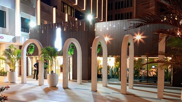 A spacious indoor area with large pillars, potted plants, and a modern architectural design. - Wow Amazing BurjKhalifa Sea SunSet Ship (Dubai)