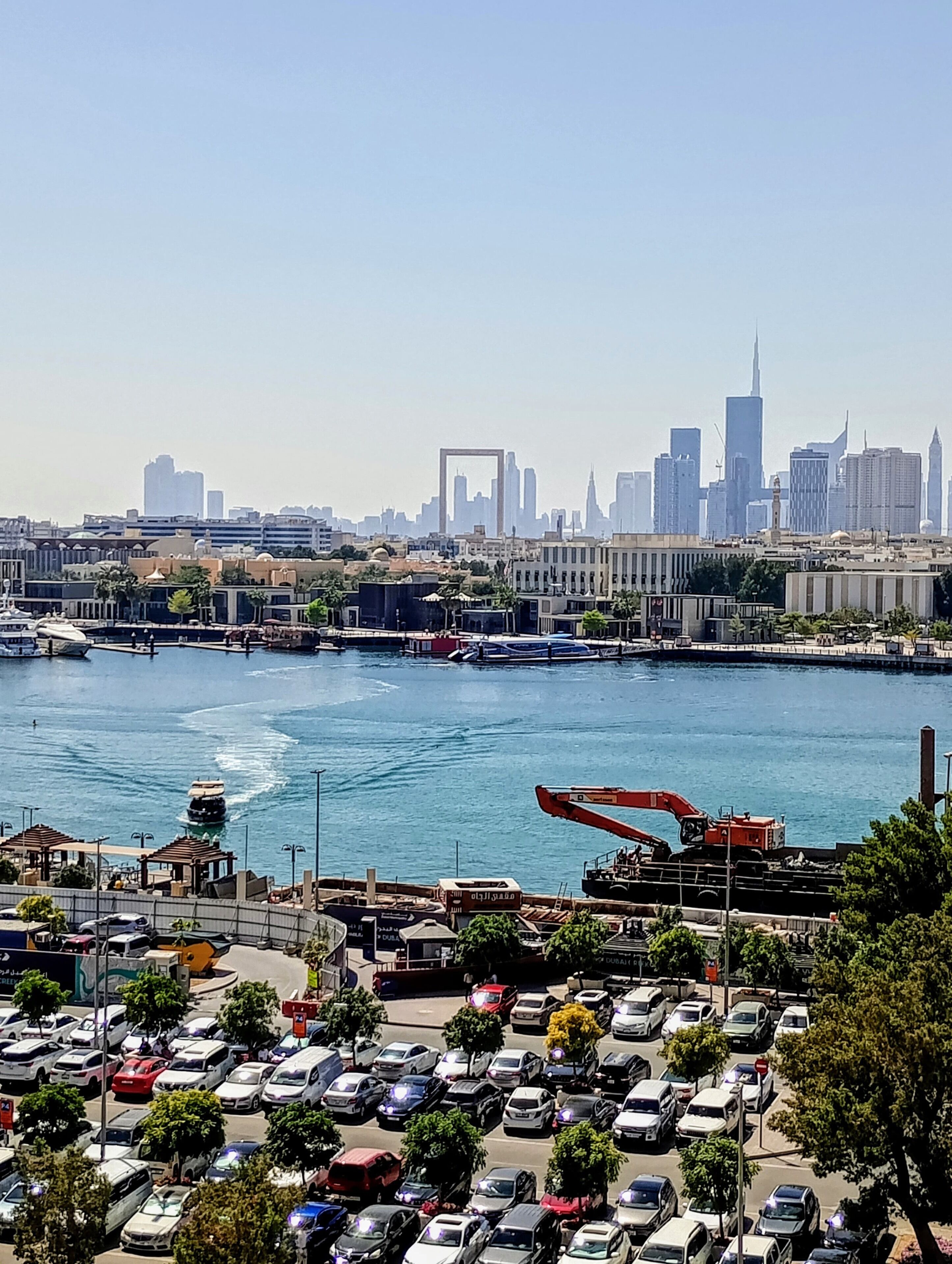 A cityscape with a marina, boats, and a crane.