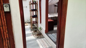 A narrow hallway with a wooden ladder, a bed with a patterned bedspread, and a small table. - Villa 5 - Modern 2 Bed Villa in Playa Chiquita (Cahuita)