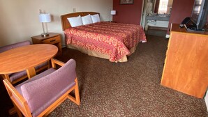 A hotel room with a bed, a desk, a chair, a lamp, and a picture on the wall. - Travel Inn San Antonio (San Antonio)