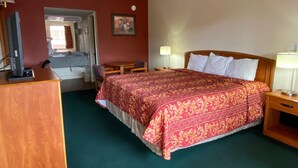 A hotel room with a bed, a desk, a chair, and a television. - Travel Inn San Antonio (San Antonio)