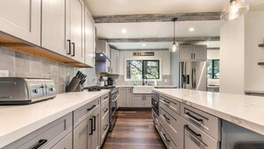 A modern kitchen with stainless steel appliances, grey cabinets, and a central island. - 3 Bedroom Lake View Condo- #44 (Kings Beach)
