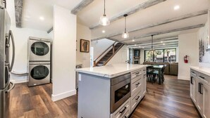 A modern kitchen with a central island, stainless steel appliances, and a herringbone wood floor. - 3 Bedroom Lake View Condo- #44 (Kings Beach)