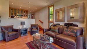 A spacious living room with leather sofas, a glass coffee table, and a fireplace. - Lakefront Condo in Kings Beach- #19 (Kings Beach)