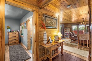 Interior de madera con un escritorio, una silla y un cuadro en la pared.