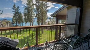 A balcony with a view of a lake and mountains, furnished with metal chairs and a table. - Feels Like Home! #24 (Kings Beach)