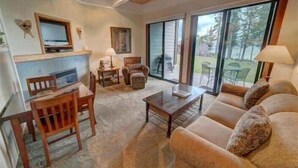 Een woonkamer met een open haard, een bank, een salontafel en een televisie.