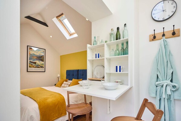 Una habitación moderna con una cama, un escritorio y un reloj en la pared.